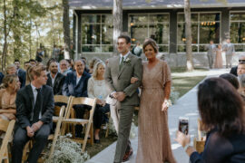 Groom walks his mom down the aisle in outdoor ceremony