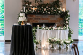 Sweetheart head table and cake table in front of fireplace